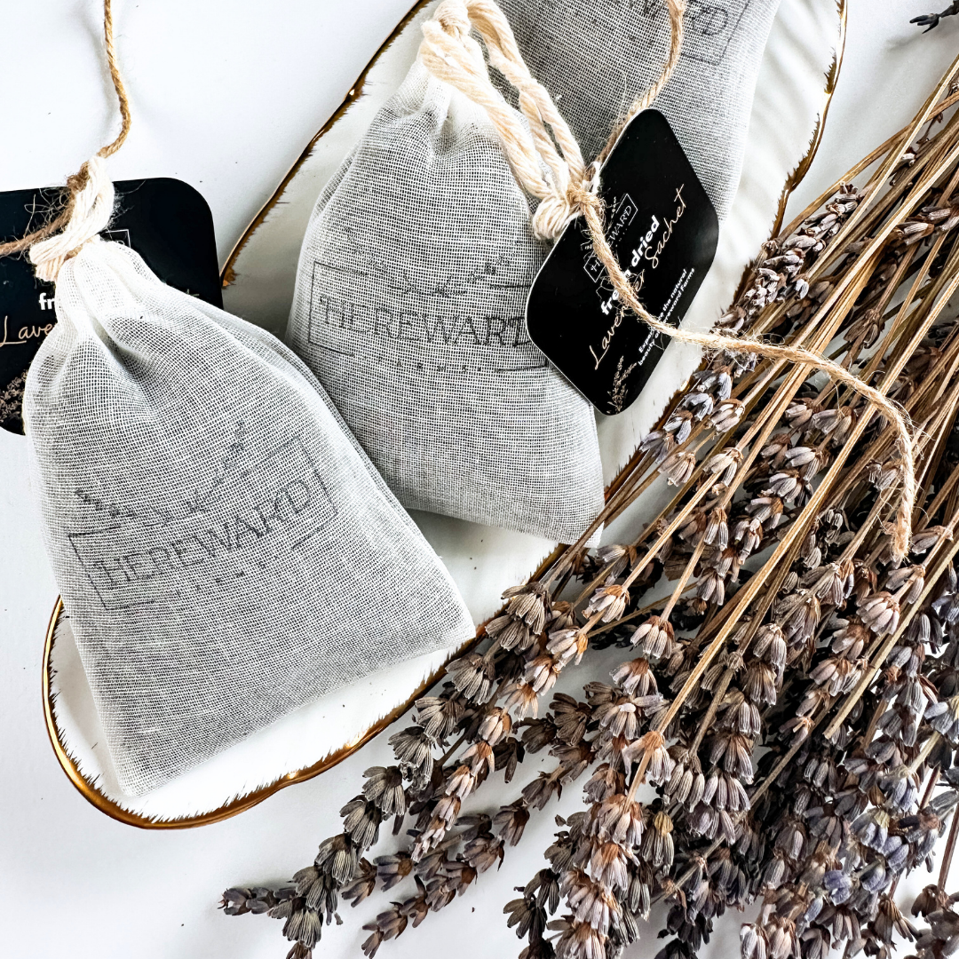 Two gray drawstring bags labeled 'The Reward' with lavender on a white surface.