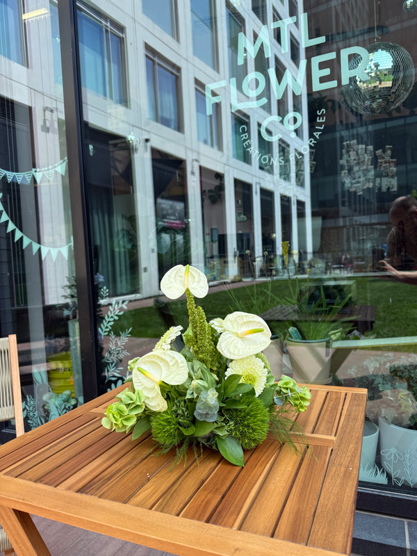 Floral arrangement on a table with a building reflection in the background