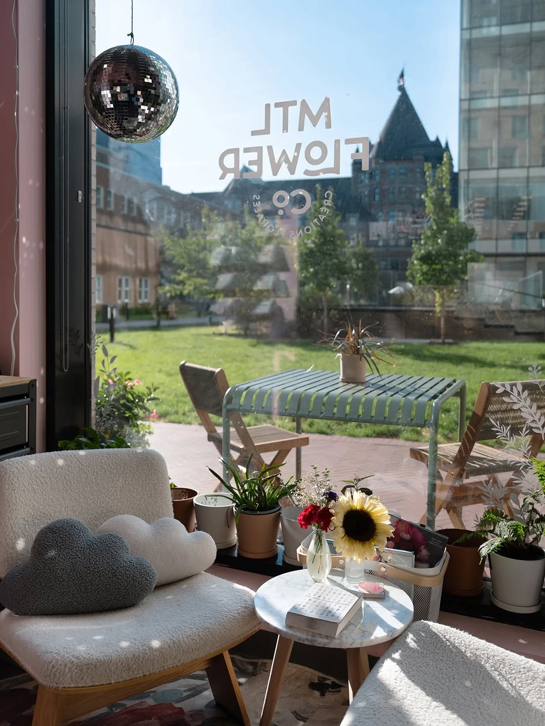 Modern interior with a view of a garden and cityscape through a large window.