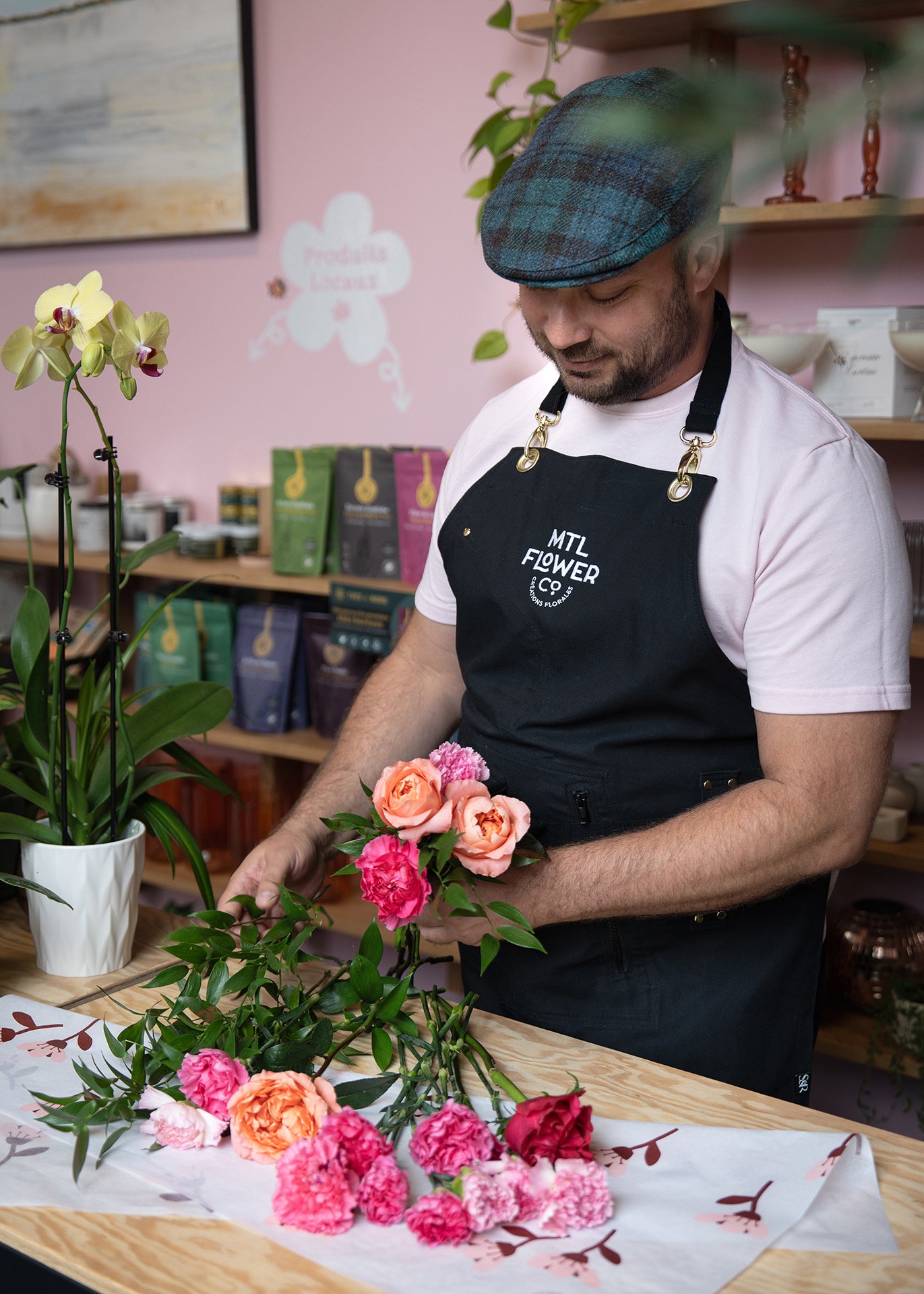 Florist arranging flowers in a shop setting with books and decor in the background