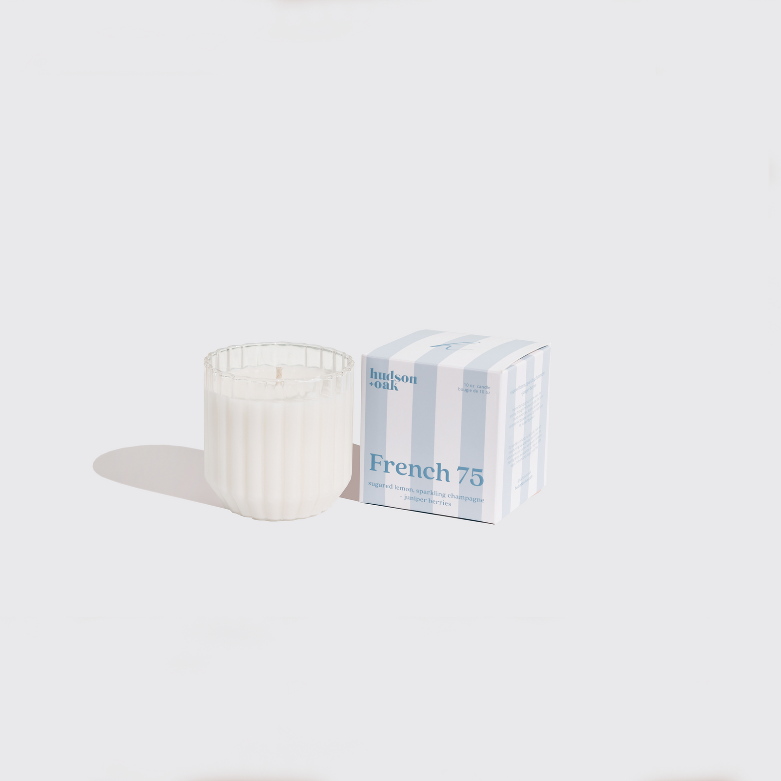 Candle and packaging labeled 'French 75' on a white background