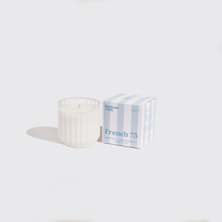 Candle and packaging labeled 'French 75' on a white background