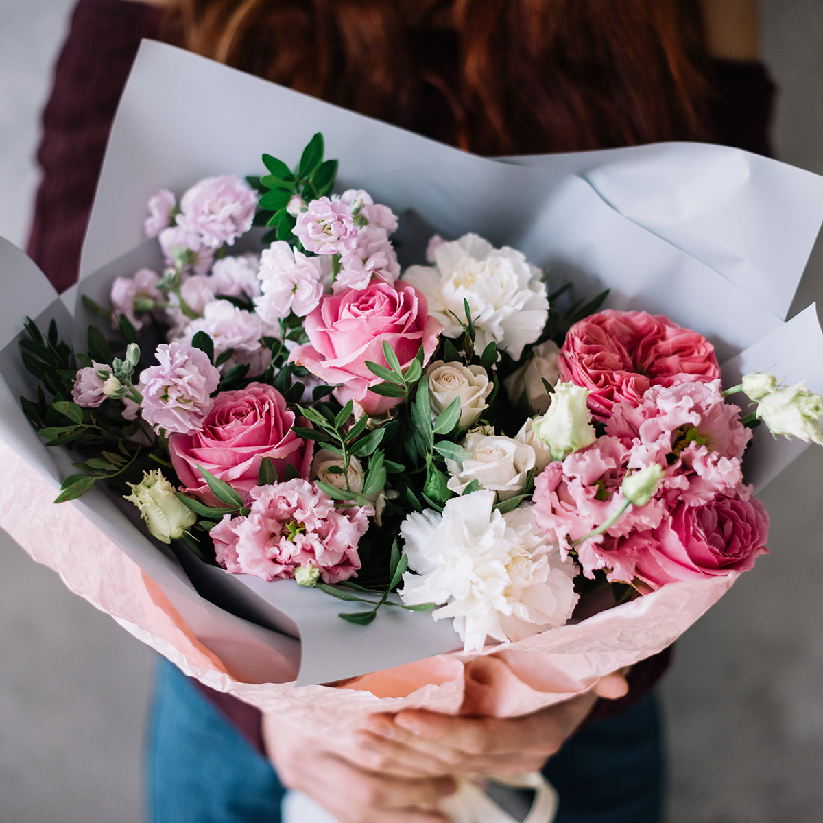 Bouquet of pink and white flowers held by a person